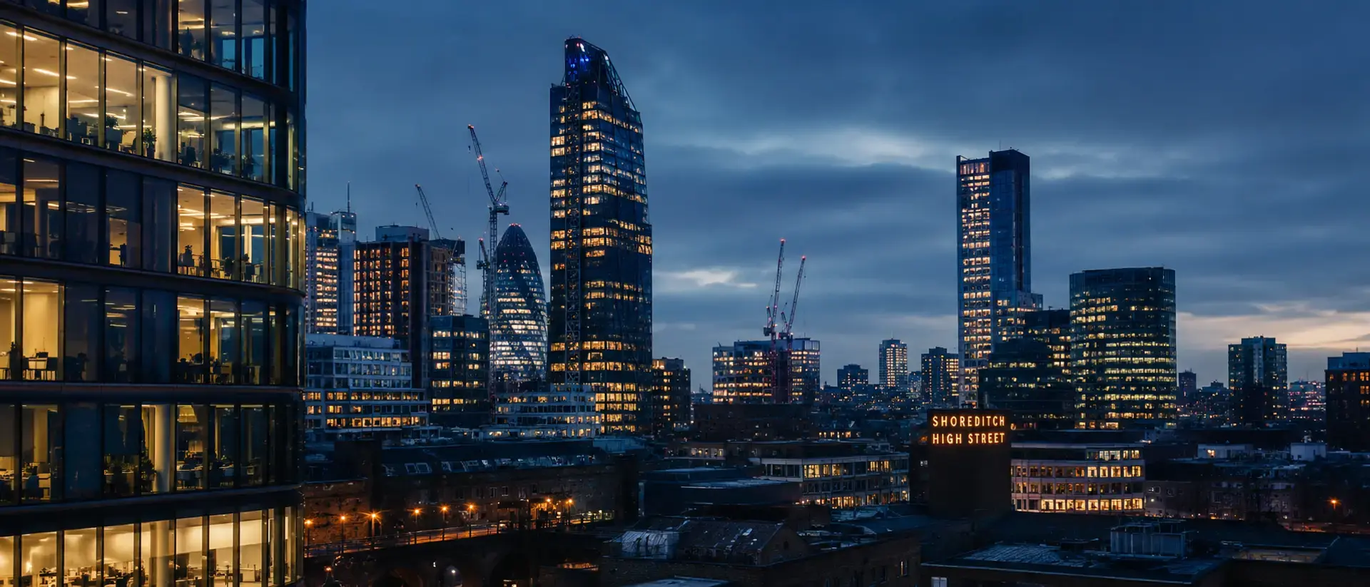 London skyline at dusk near Shoreditch High Street, office lights glowing