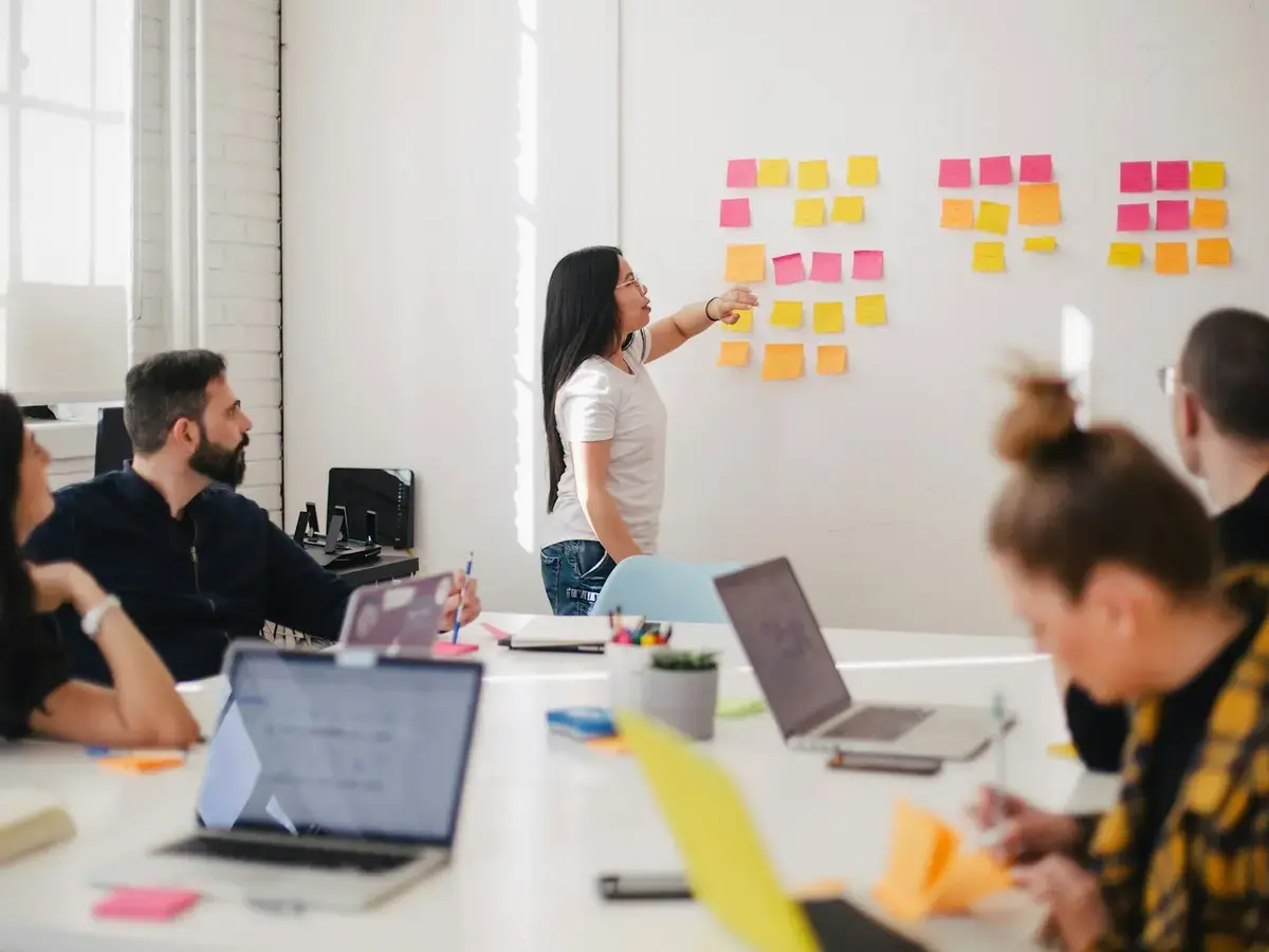 Team mapping a client workflow with sticky notes on an office wall